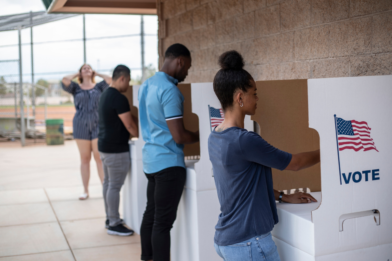 People casting ballots at voting booths